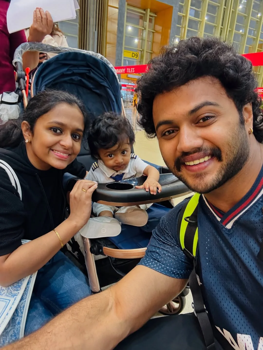 Photo by Avinash Ashok on February 15, 2026. May be a selfie of one or more people, beard, baby, people smiling, buggy and text that says 'D9 MANY ILES'.