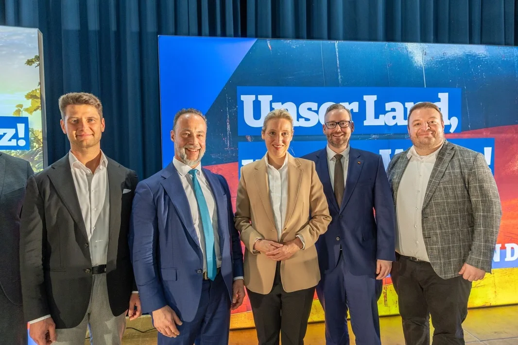 Photo shared by Alice Weidel on February 21, 2026 tagging @damianlohr, and @sebastian.muenzenmaier.afd. May be an image of standing, office and text that says 'Z! けっ U UnsorLar ISC La Lar! B UTN ሸ ID'.